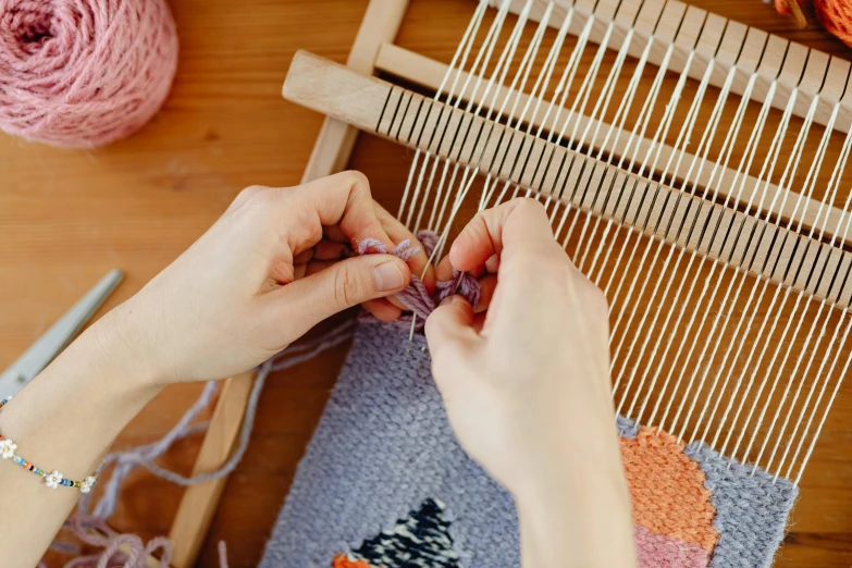 someone is working with yarn on an old loom