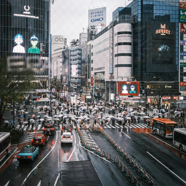 cars driving down a city street with buildings and traffic