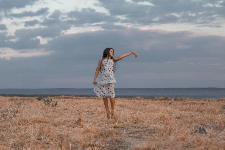 a  in a floral dress is pointing into the sky