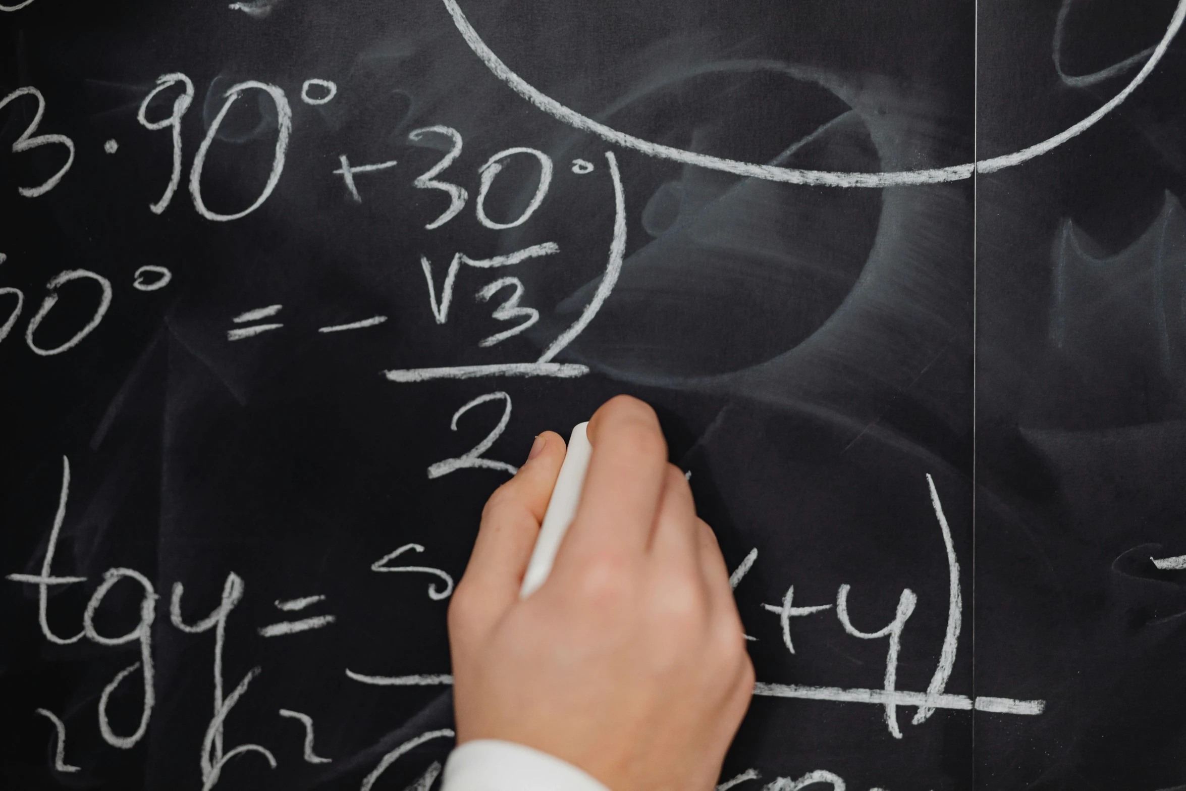 a person writing numbers on a blackboard