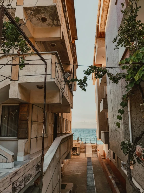 a street in front of an apartment building looking down at the ocean