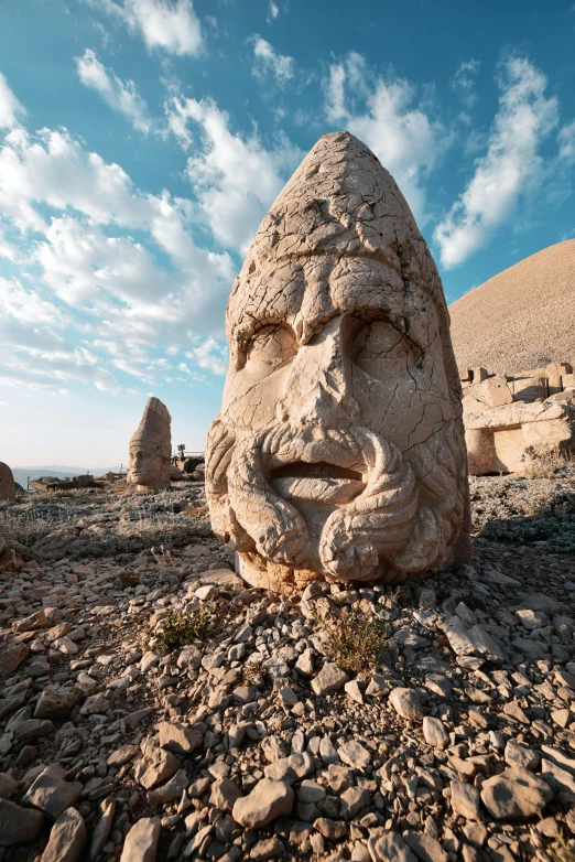 a stone sculpture with its face on top of a rocky terrain