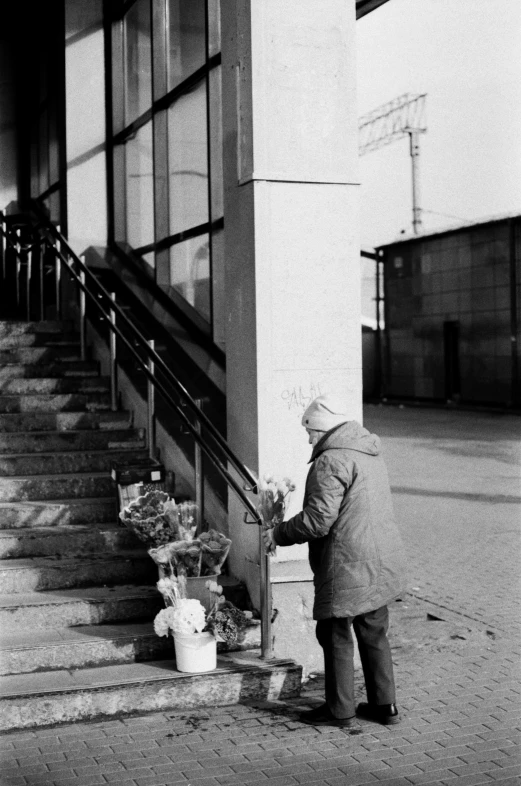 a man putting flowers in a bucket at the bottom of stairs