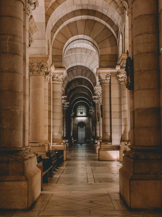 an empty hallway with large statues on the sides of it