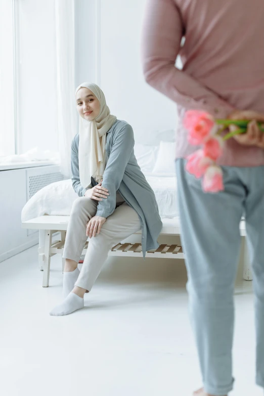 a woman wearing a hijab while sitting on a bed