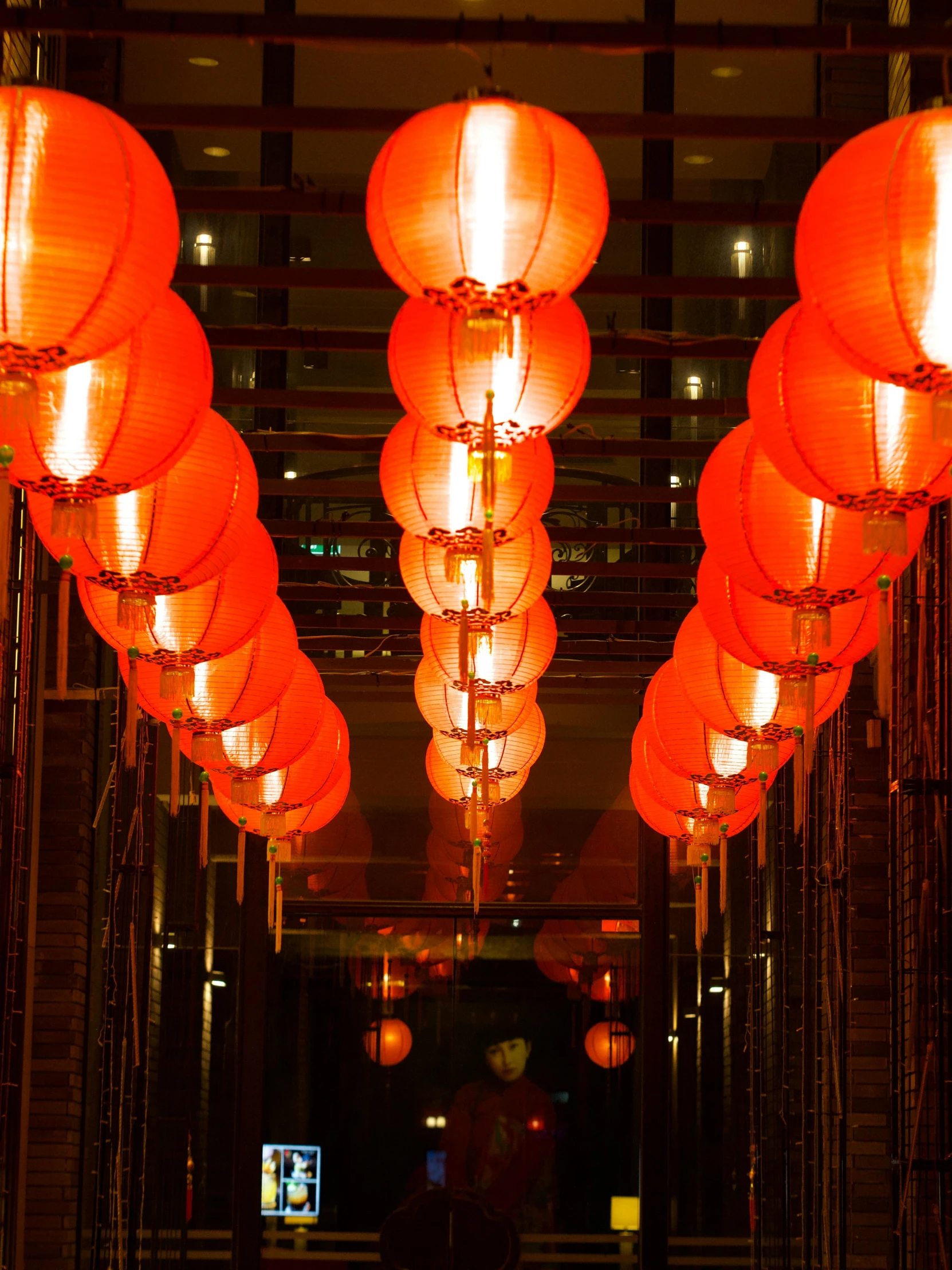 a walkway with several large red lanterns all over