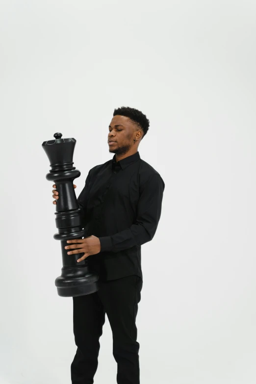 a black man holding up a chess piece to his face