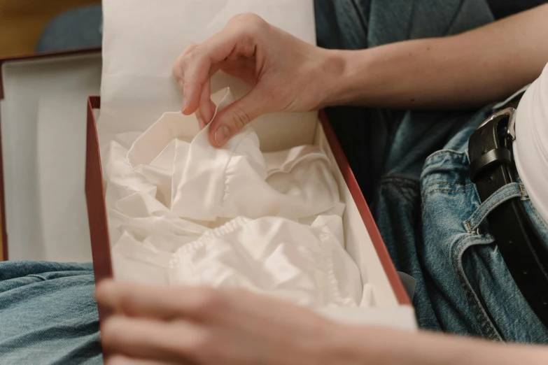 a man's hands are removing an object from a box