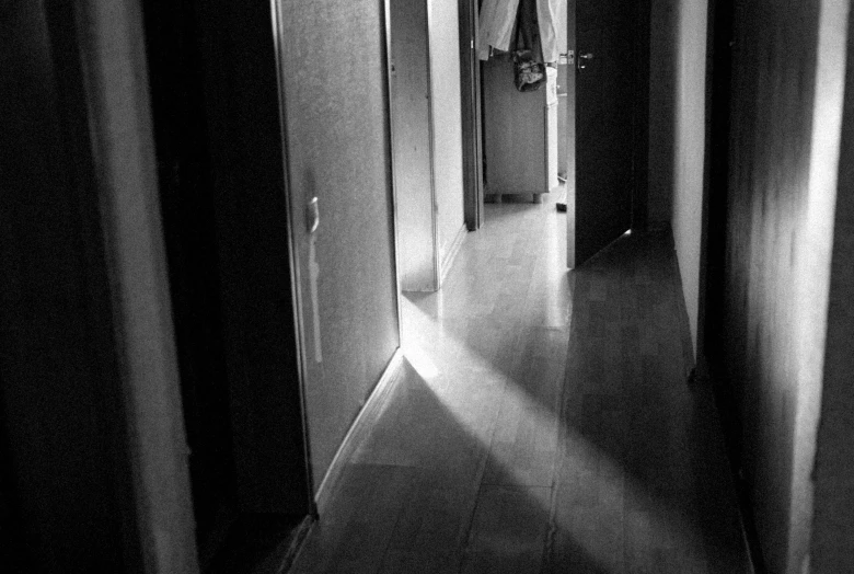 a light shines from behind the curtain in a dark hallway