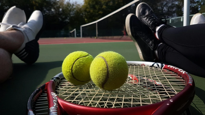 two tennis balls are on top of a racket