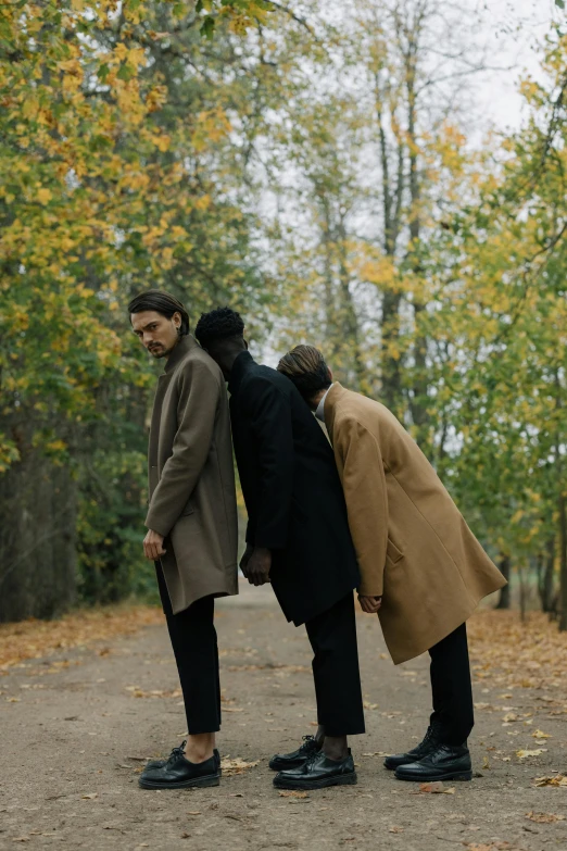 three men in coats are standing near each other