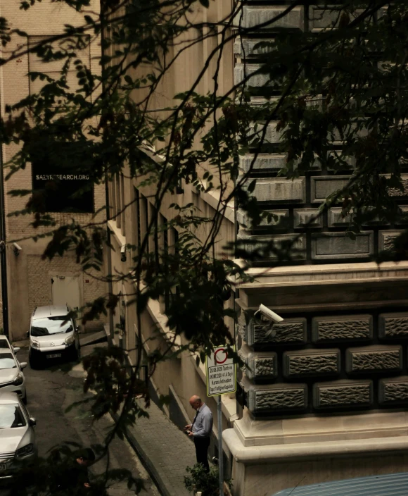 a man walks near a steep hill in front of some buildings