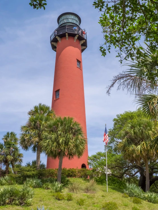 the red lighthouse is on top of a hill