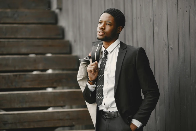 a man in a suit is holding an umbrella