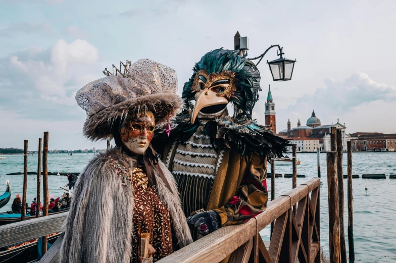 two men are dressed as they stand next to each other near a pier