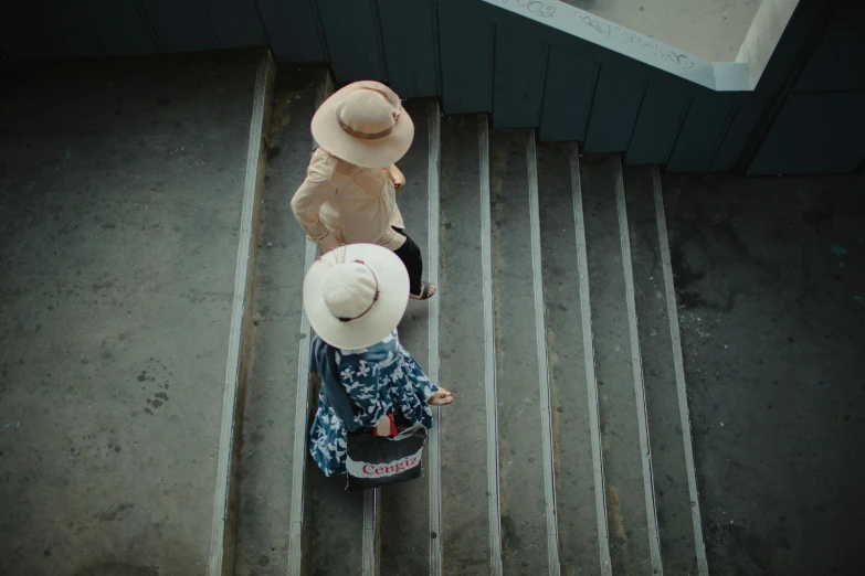 a couple of people with hats standing on a stair case