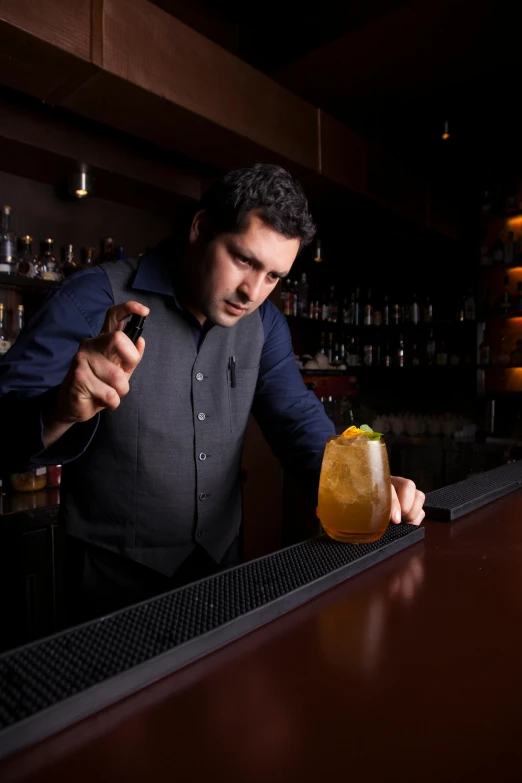 a man holding a drink near the bar