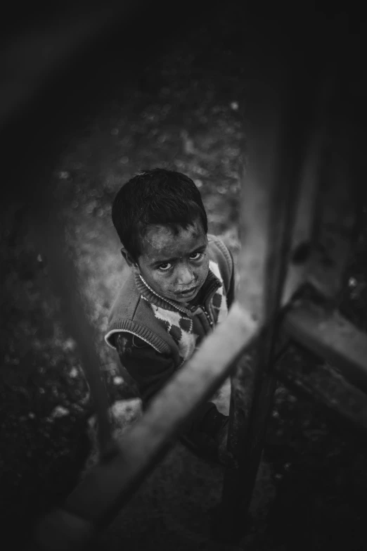 a child standing up by himself and looking at soing