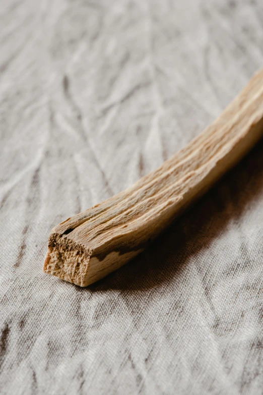 wood laying on white linen covered bed with no sheets