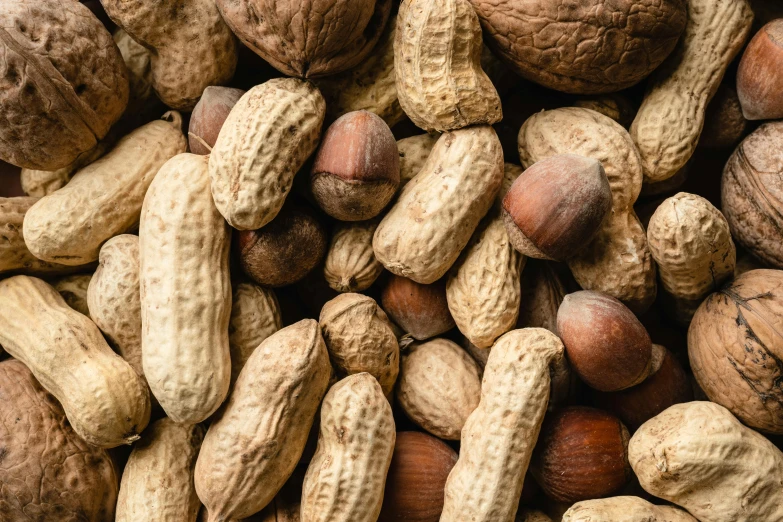 nuts, nutshells and peanuts are piled on top of each other