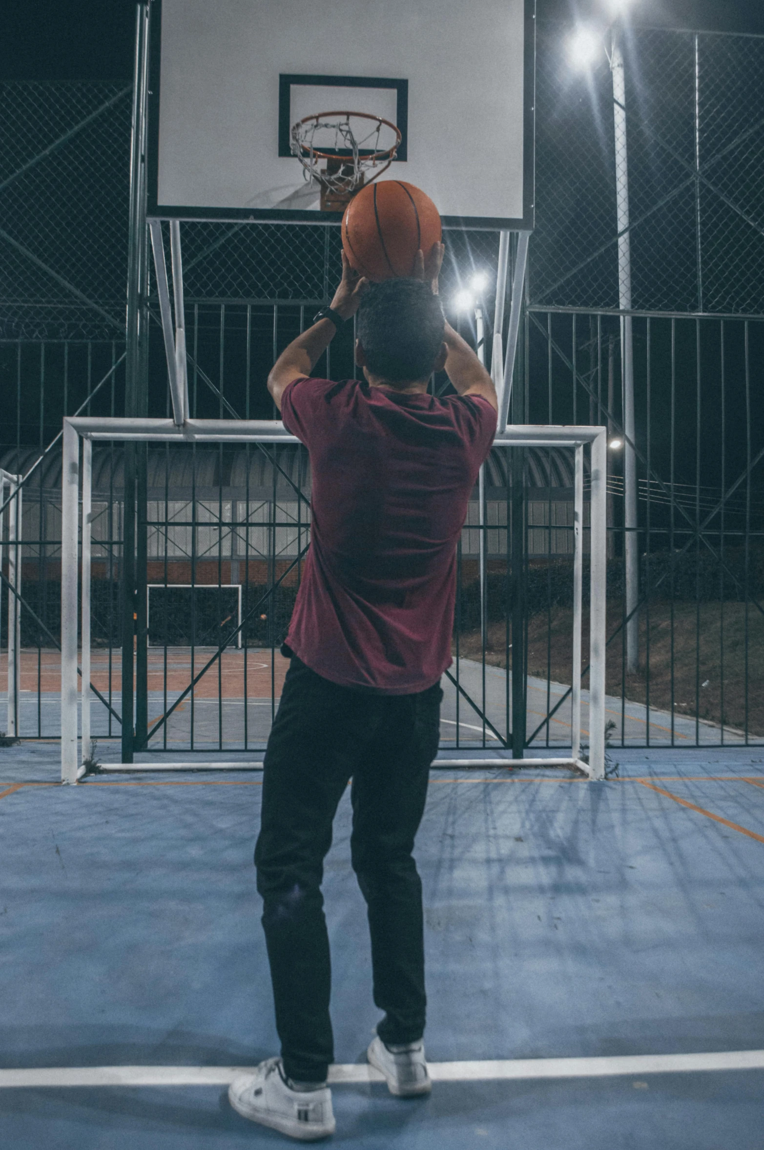 a man in a pink shirt is throwing a basketball