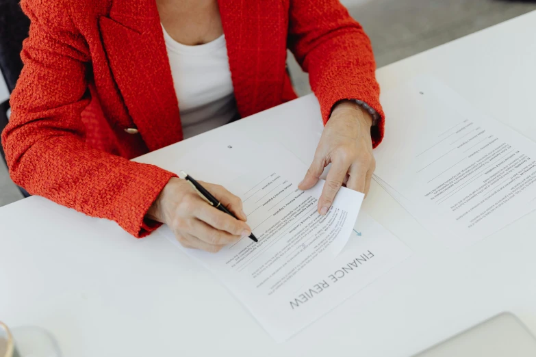 there is a woman that has a pen in her hand and has papers with numbers on them