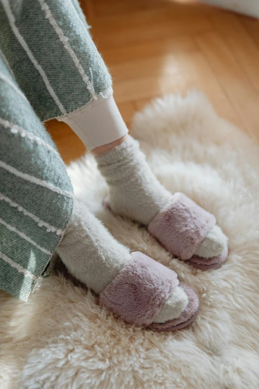 a person's feet with striped socks, on a white gy carpet