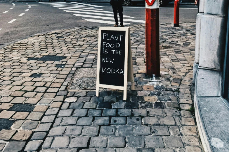 a sidewalk sign sitting on the side of a road