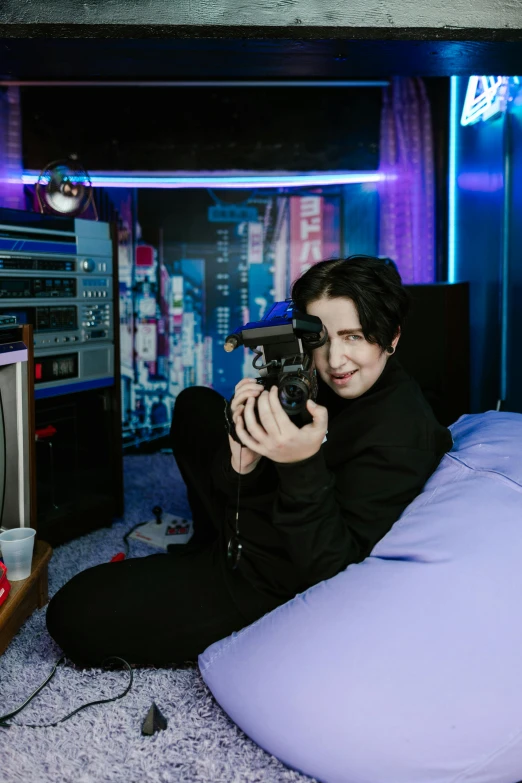 a man sitting on a bean bag chair holding a camera