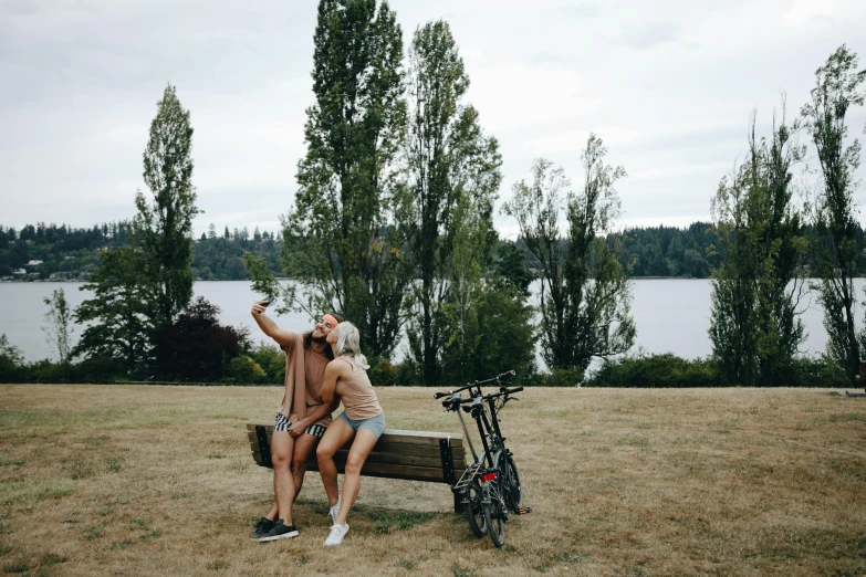 two people sitting on a bench next to a bike