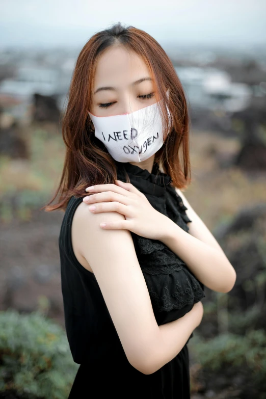 a woman in black is wearing a mask with the words japan on it