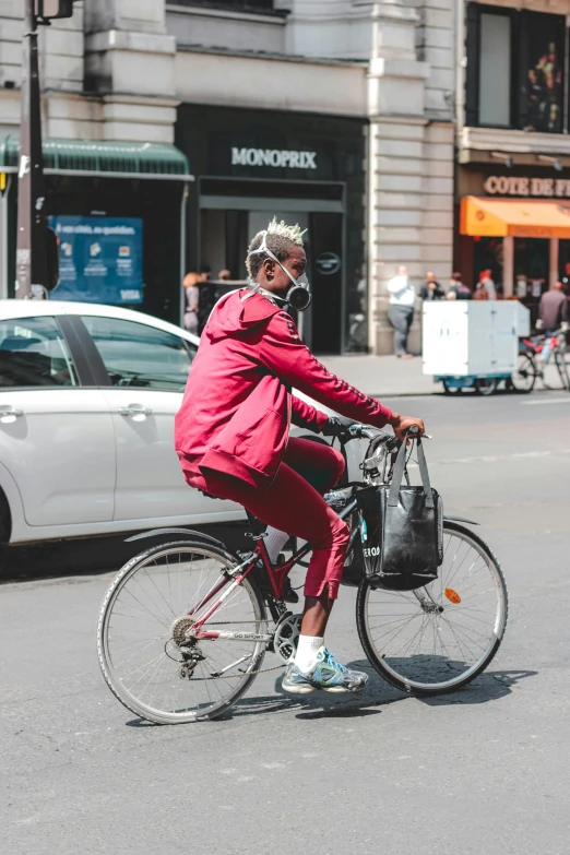 man in pink riding on bicycle across street