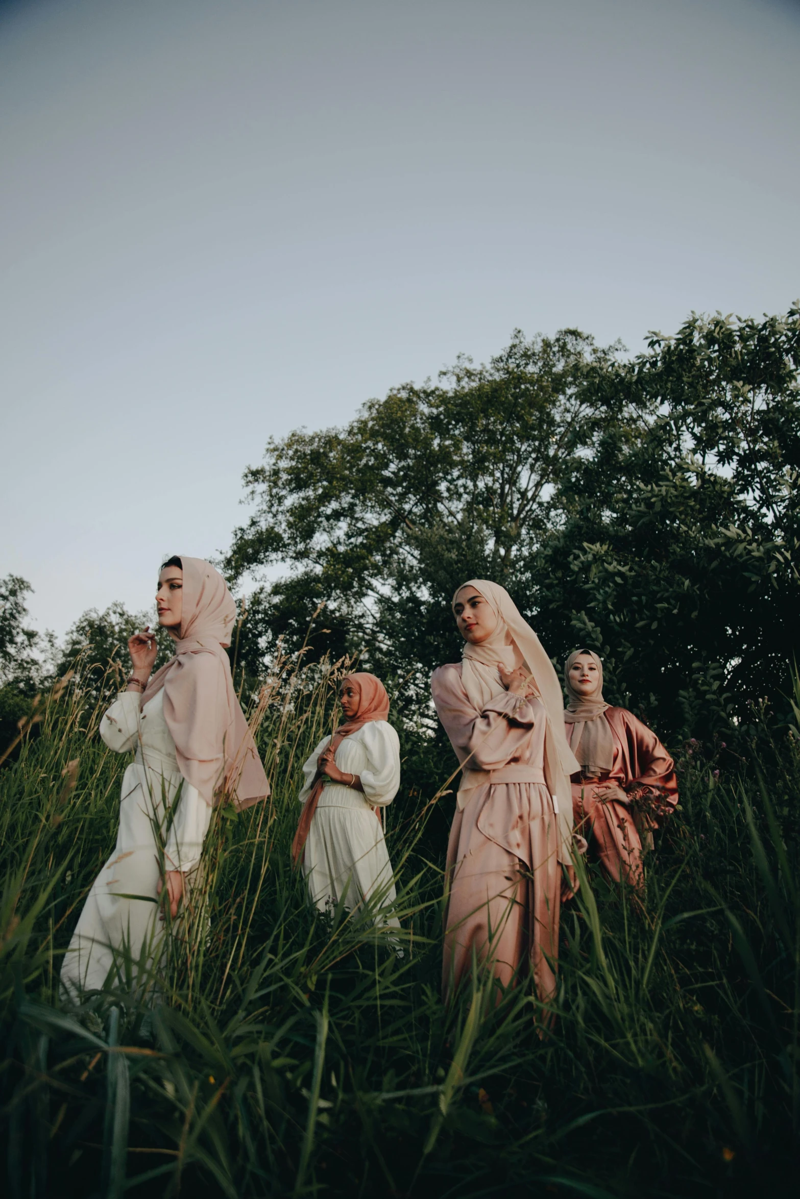 three people dressed in period garb standing together in tall grass