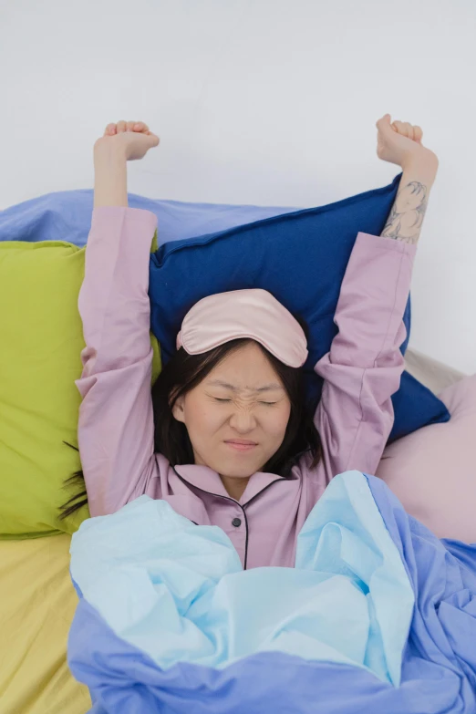 a woman laying in bed under the covers with her head