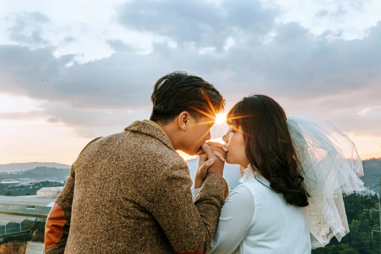 bride and groom standing at edge of viewpoint in cloudy sky