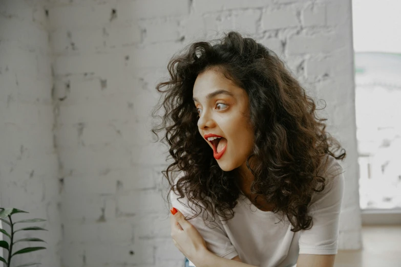 a woman with curly hair brushes her teeth