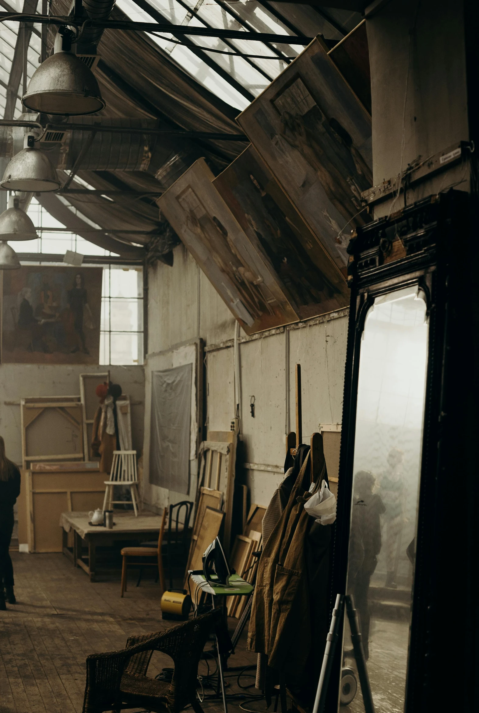 an unfinished building with chairs, art equipment, and a person standing in the doorway