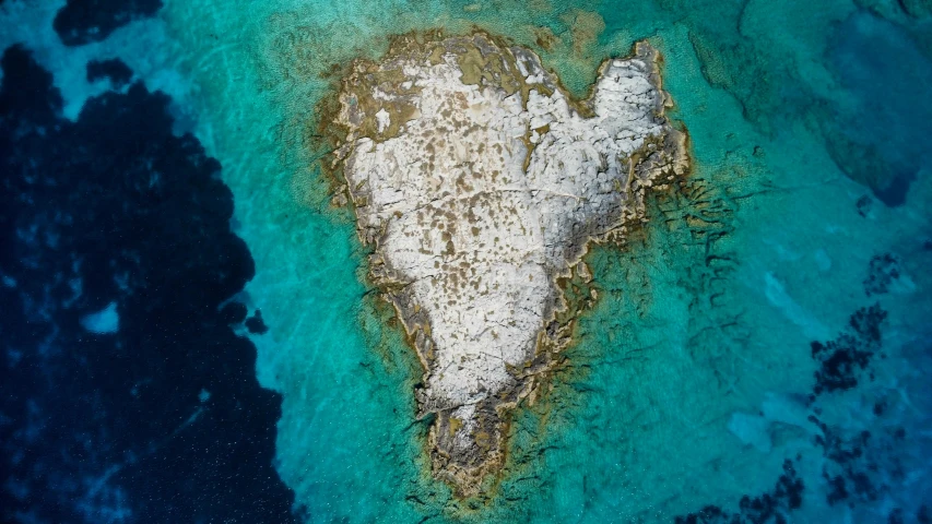 a aerial view of a large rock formation in the water