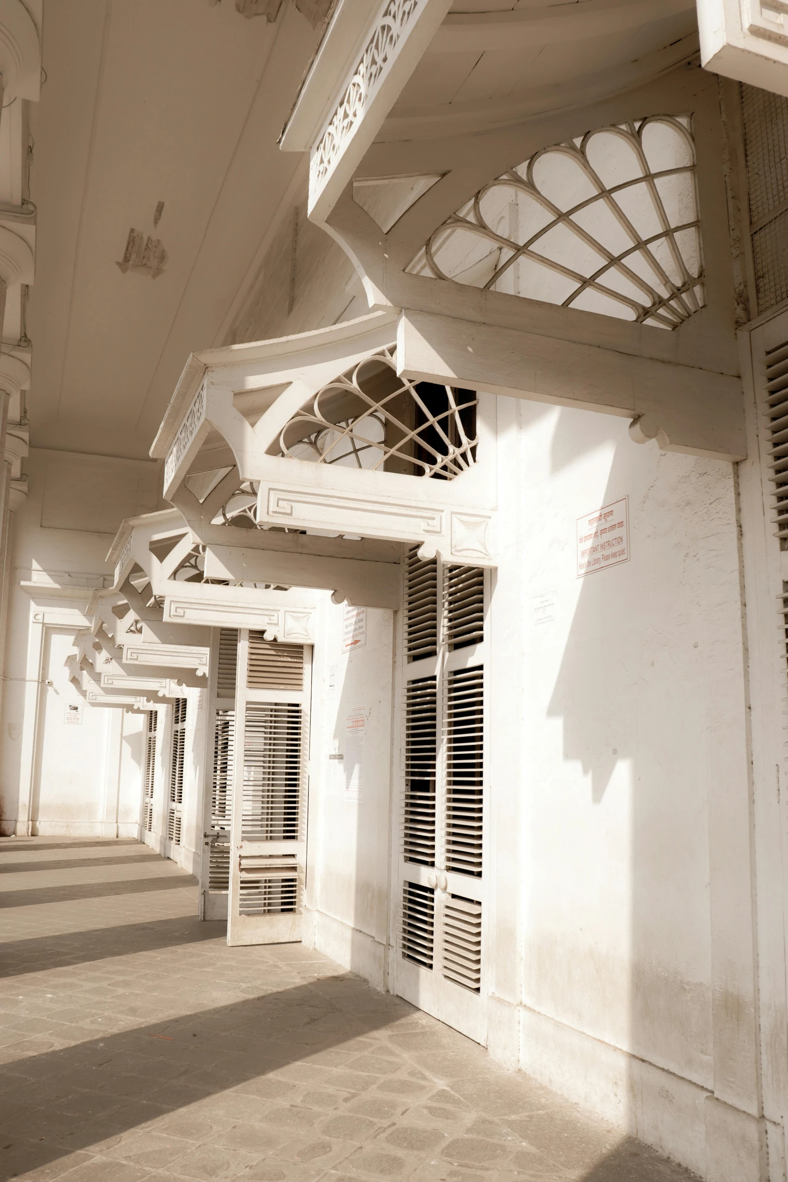 a row of white arched wooden structures outside