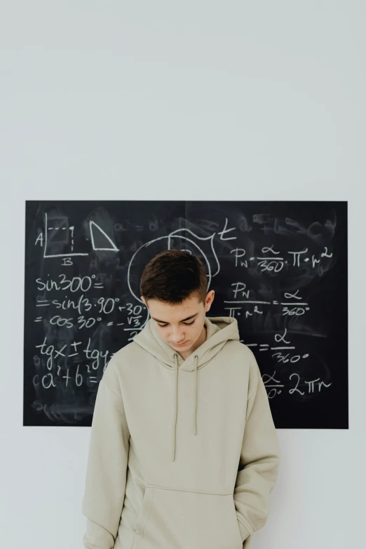 a young man standing in front of a chalkboard