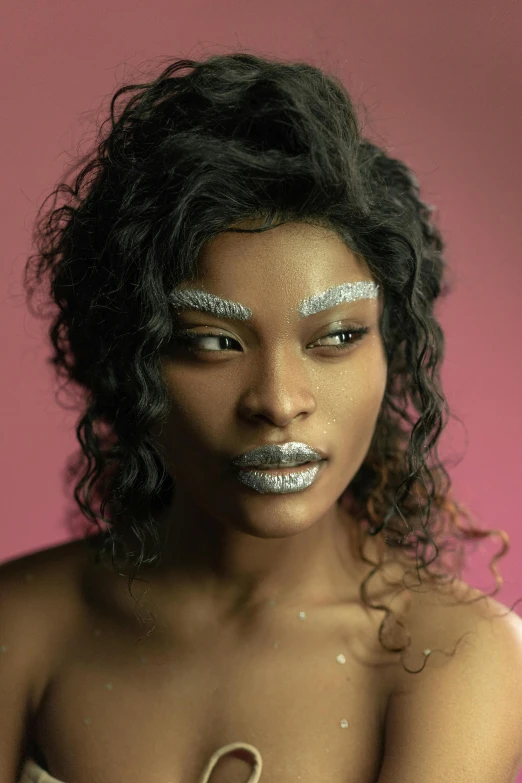 a woman with silver glitters on her face and hands