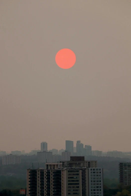 the sun sets over a cityscape and skyline