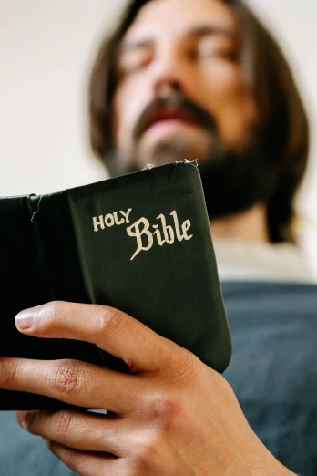 a man holding a bible in his hands