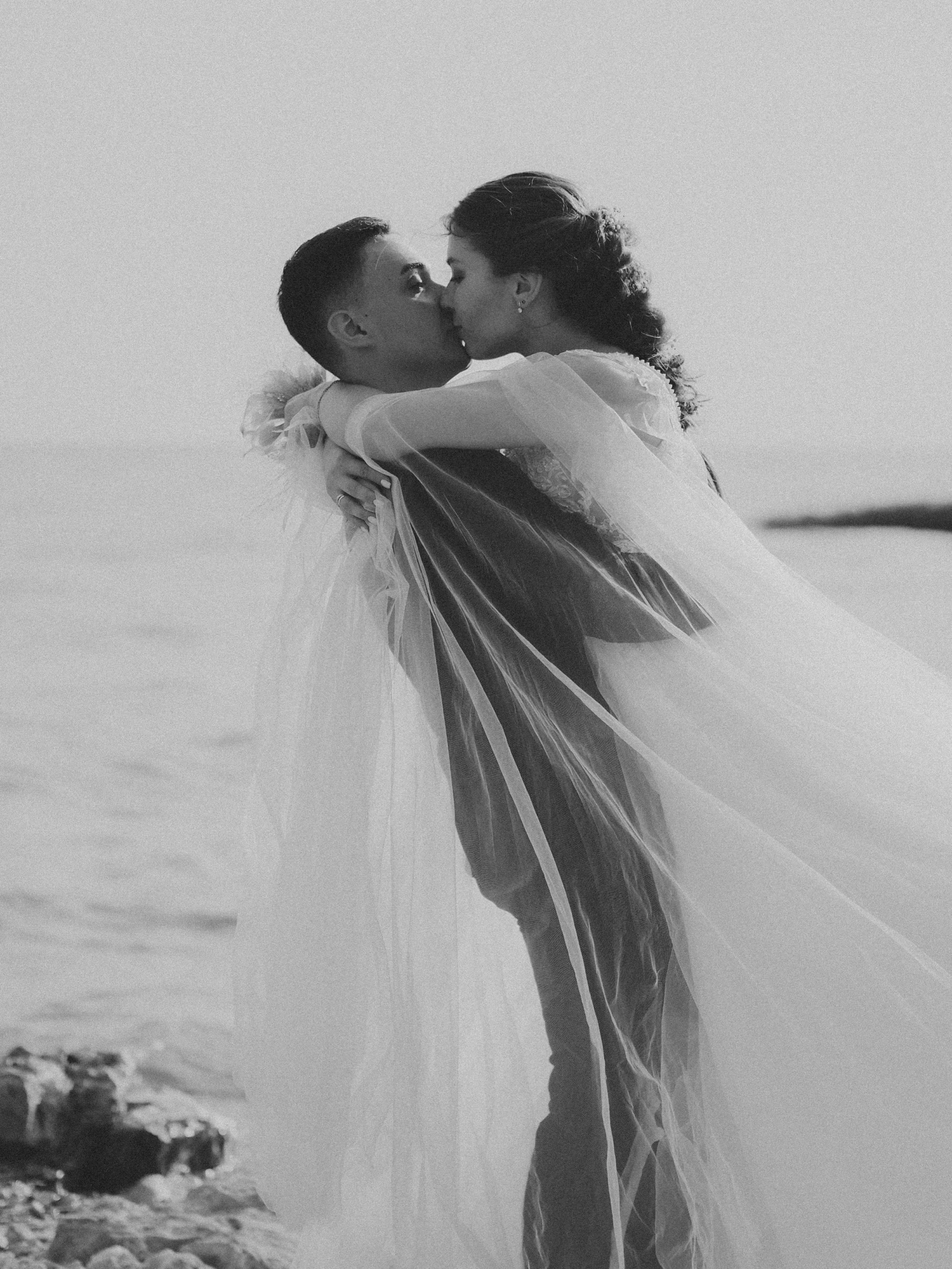 newlywed couple emce on beach in black and white po