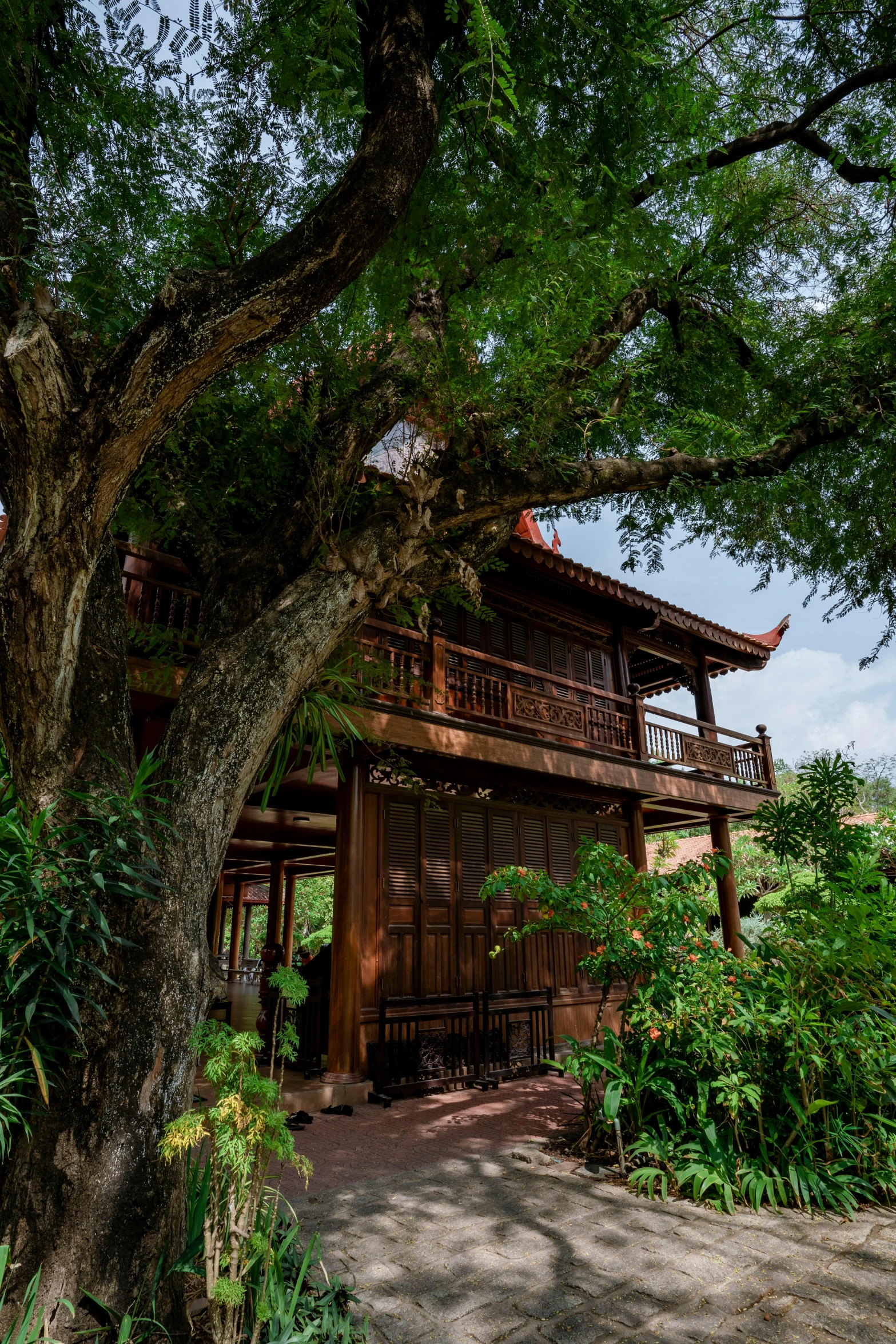 a building with lots of trees and bushes next to it