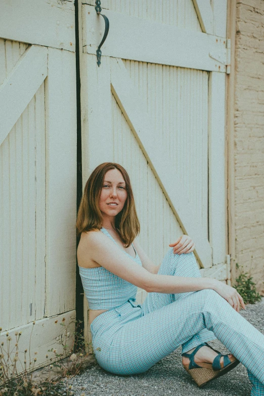 a young woman sitting in front of an open gate