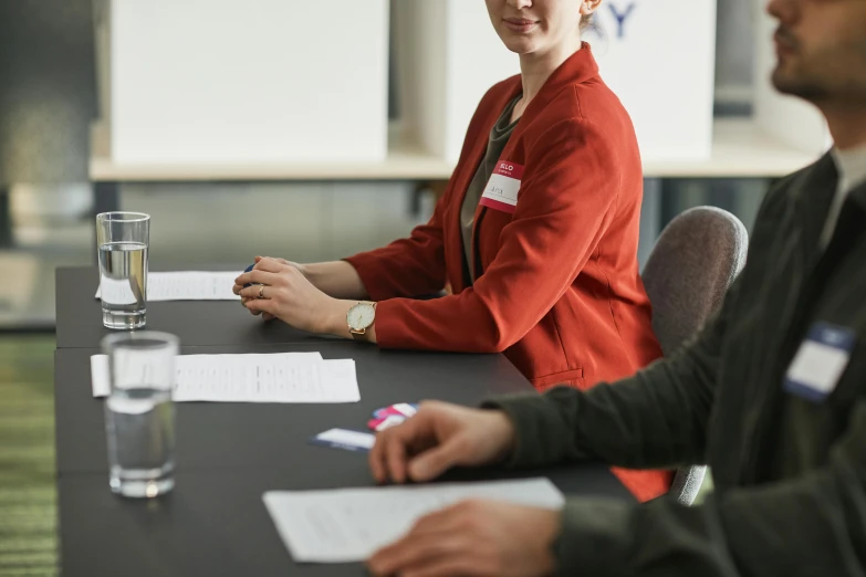 a woman in red sitting next to a man at a table