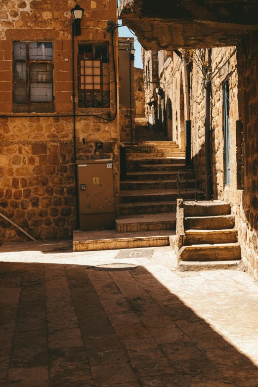 a very narrow alley way with steps down and a mail box in the doorway