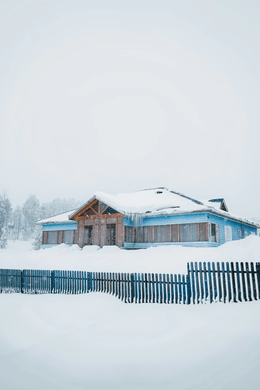 a building covered in snow on top of a white field