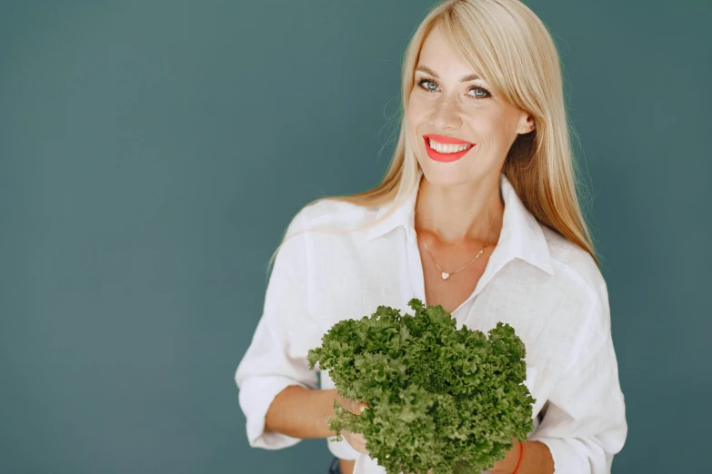 a woman is holding a piece of broccoli